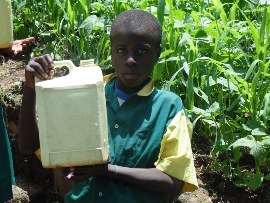 The Water Project : kenya18065-boy-holds-up-container-filled-with-water