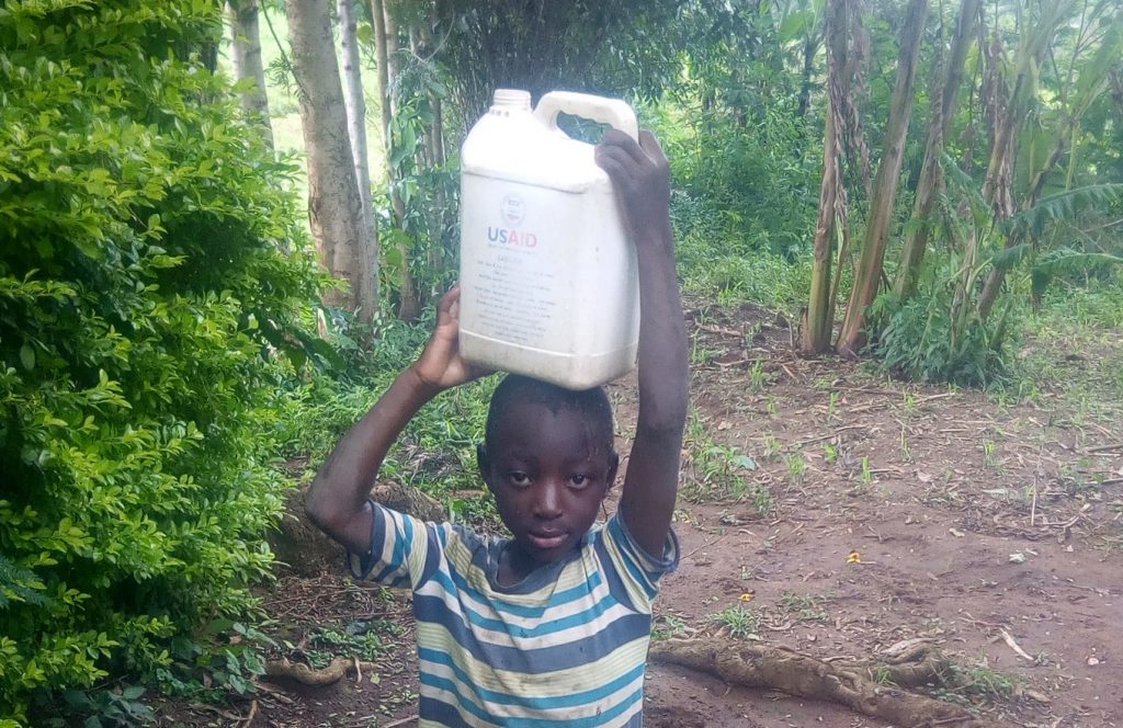 The Water Project : kenya18119-young-boy-carrying-home-water-from-the-unprotected-hole