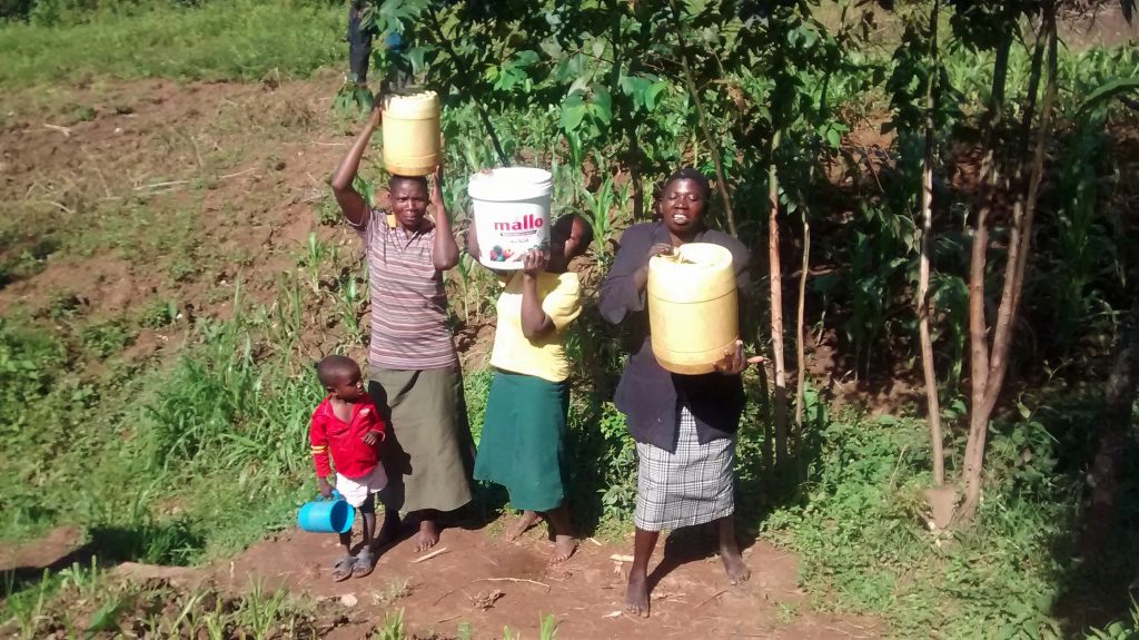 The Water Project : kenya18133-lifting-jerrycans-filled-with-water-onto-heads