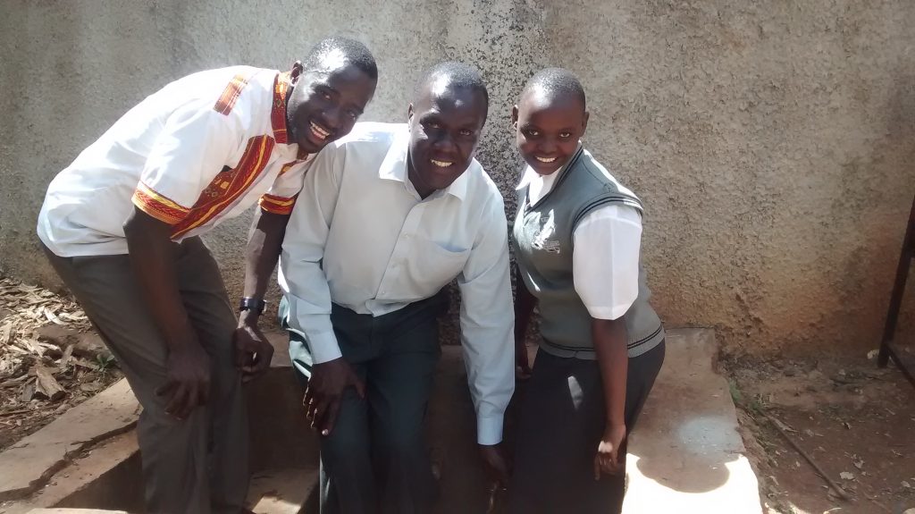 The Water Project : kenya4640-eric-wagaka-poses-with-teacher-and-student-at-the-tank
