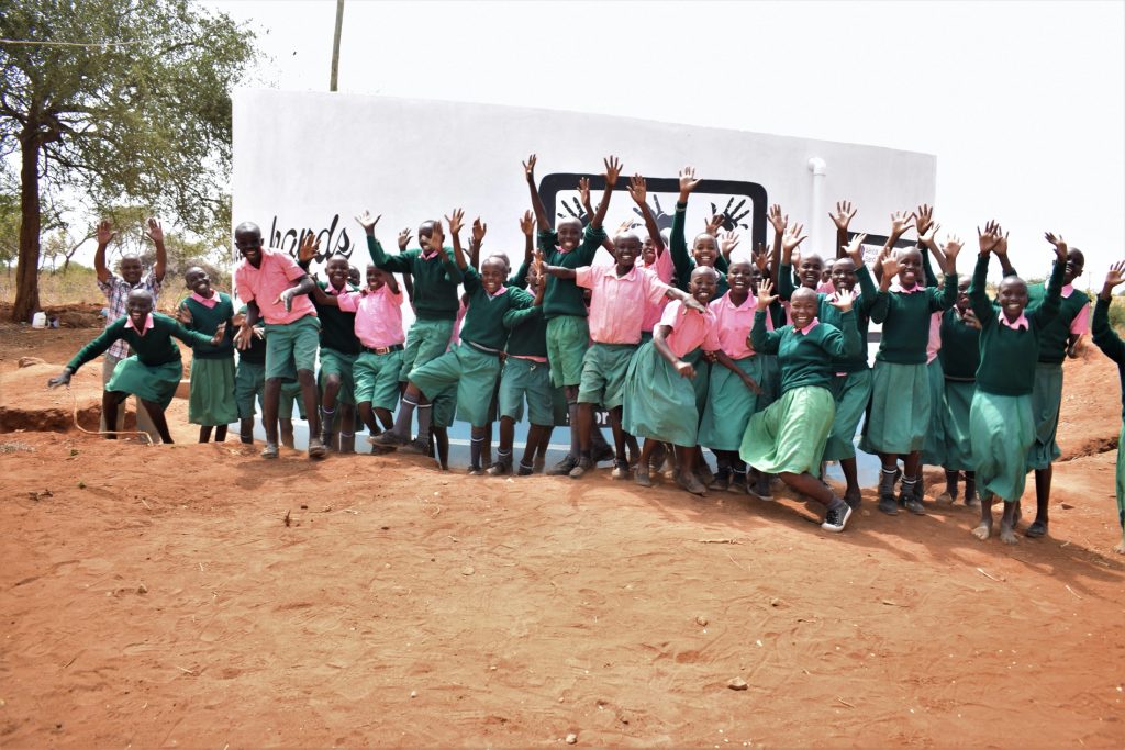 The Water Project : kenya19236-students-celebrate-in-front-of-tank