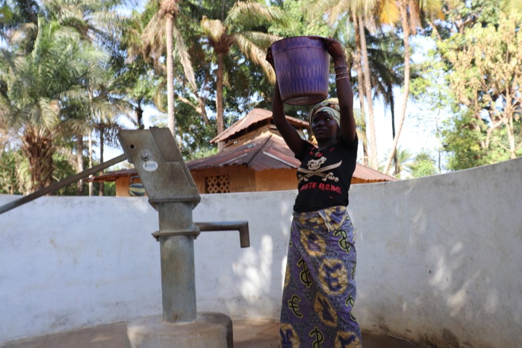 The Water Project : sierraleone18251-community-member-helping-herself-with-a-contianer-of-water