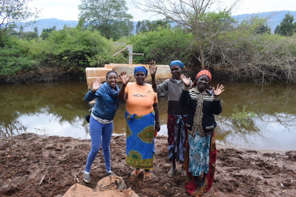 The Water Project : kenya18194-field-officer-kendi-and-community-members-at-the-well-a-year-later