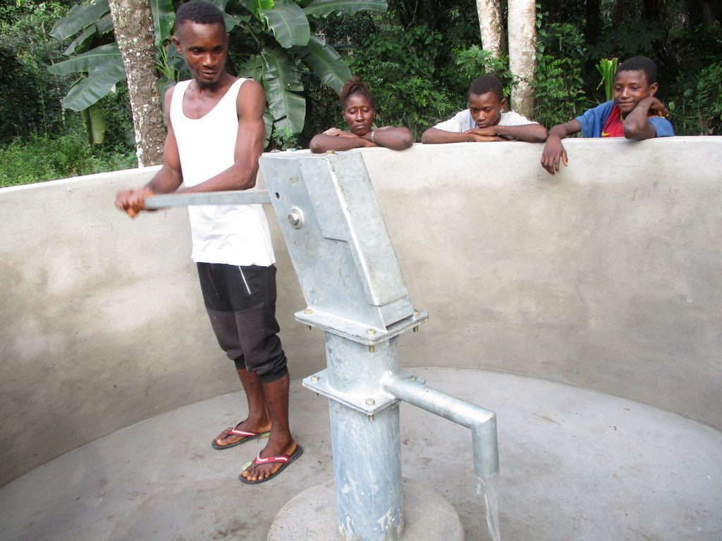 The Water Project : sierraleone18258-community-member-pumps-the-well