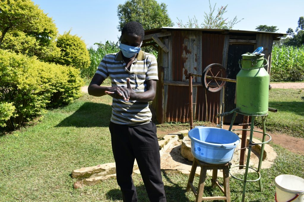 The Water Project : covid19-kenya19095-a-community-member-demonstrating-handwashing