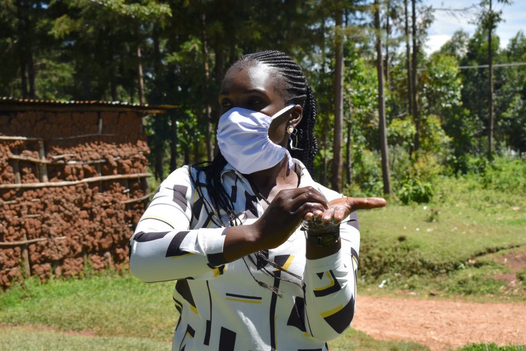 The Water Project : 6-covid19-kenya18136-miss-alulu-demonstrating-handwashing