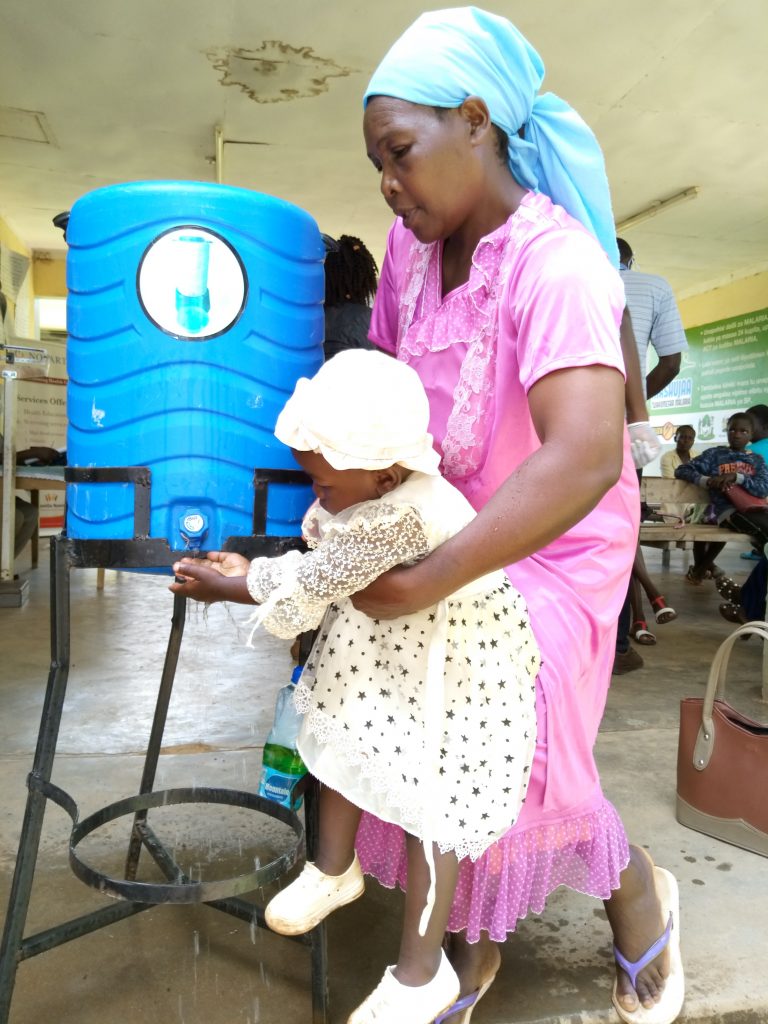 The Water Project : covid19-kenya400-mother-lifts-daughter-to-wash-her-hands