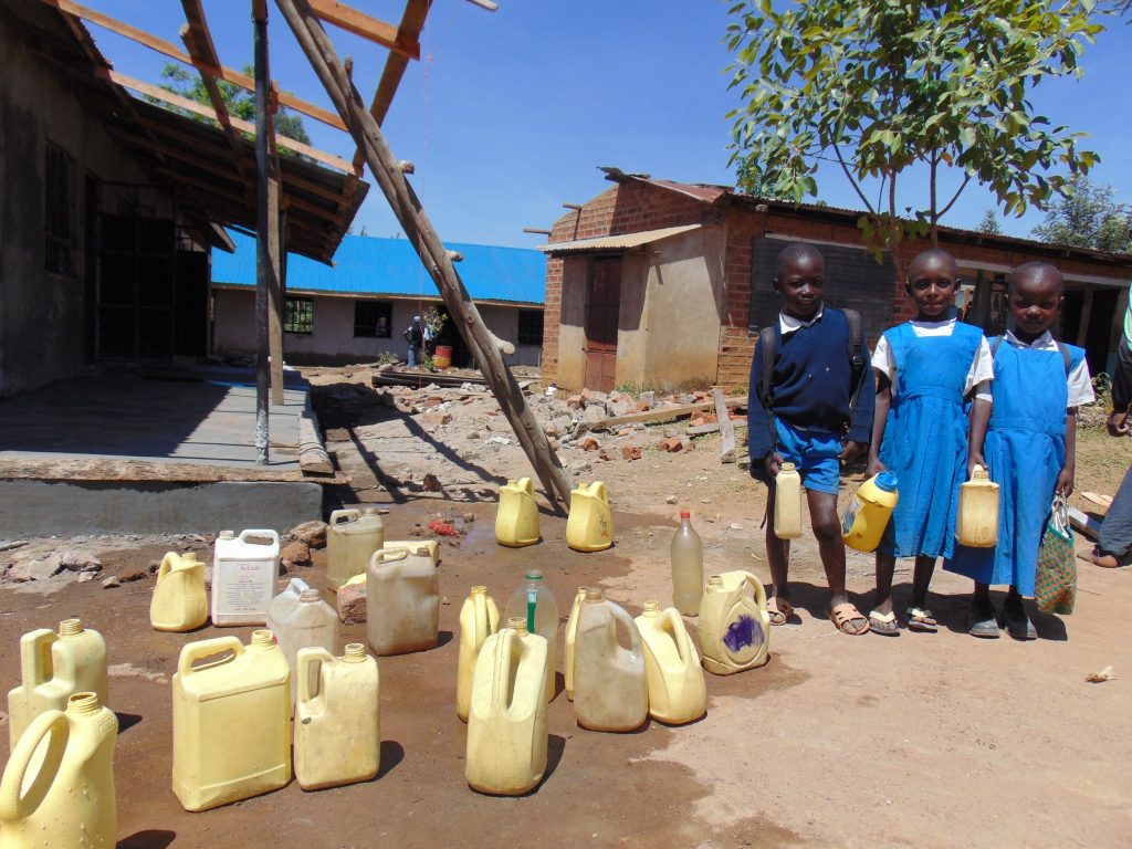 The Water Project : 20-kenya20102-pupils-with-water-containers-at-central-dropoff-point