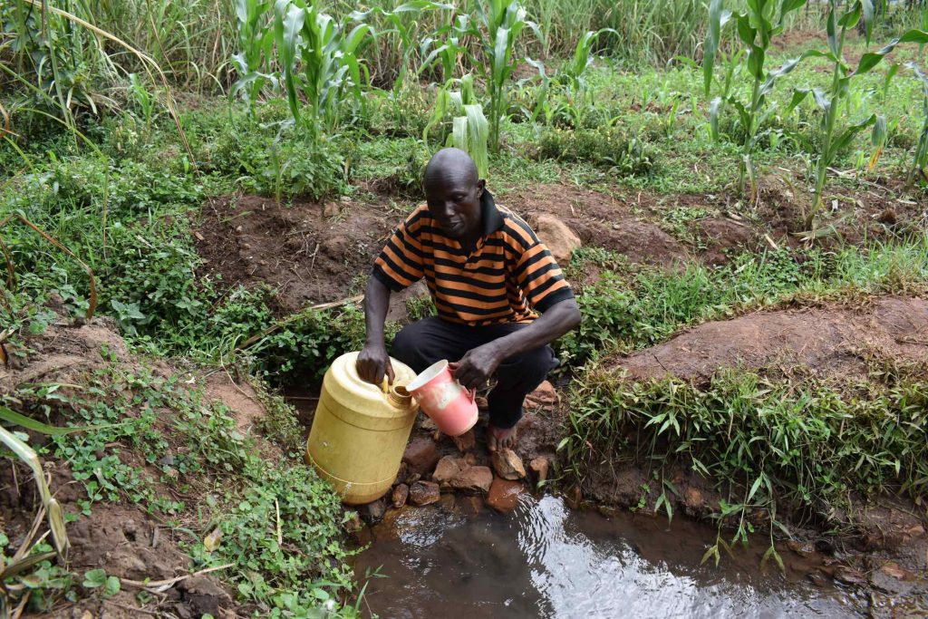 The Water Project : kenya22055-mr-luta-collects-water-2