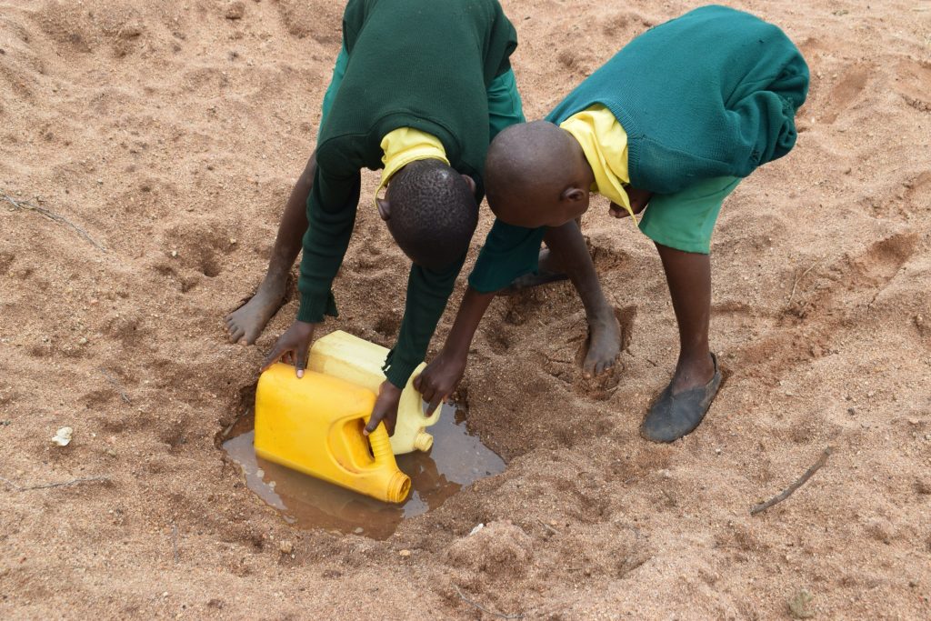 The Water Project : kenya20355-filling-up-container-with-water-2