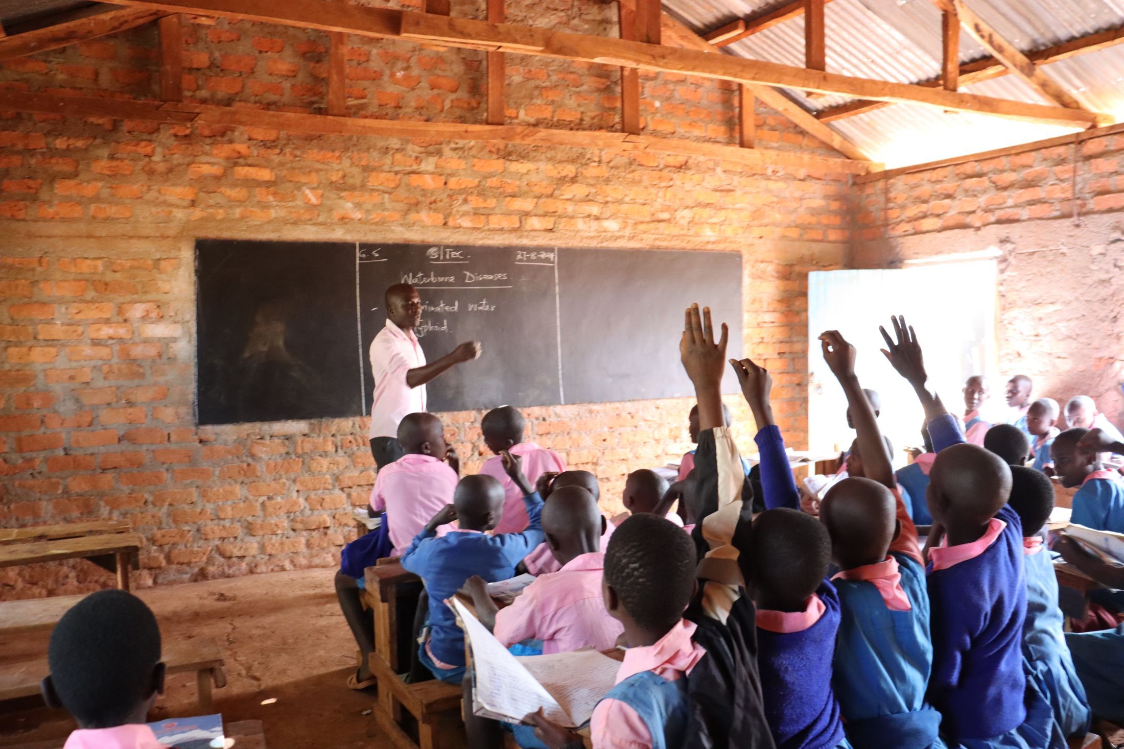 School children learning at desk with clean water access from Ethereum donation