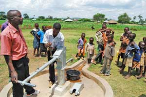 A community watches as a new pump is installed